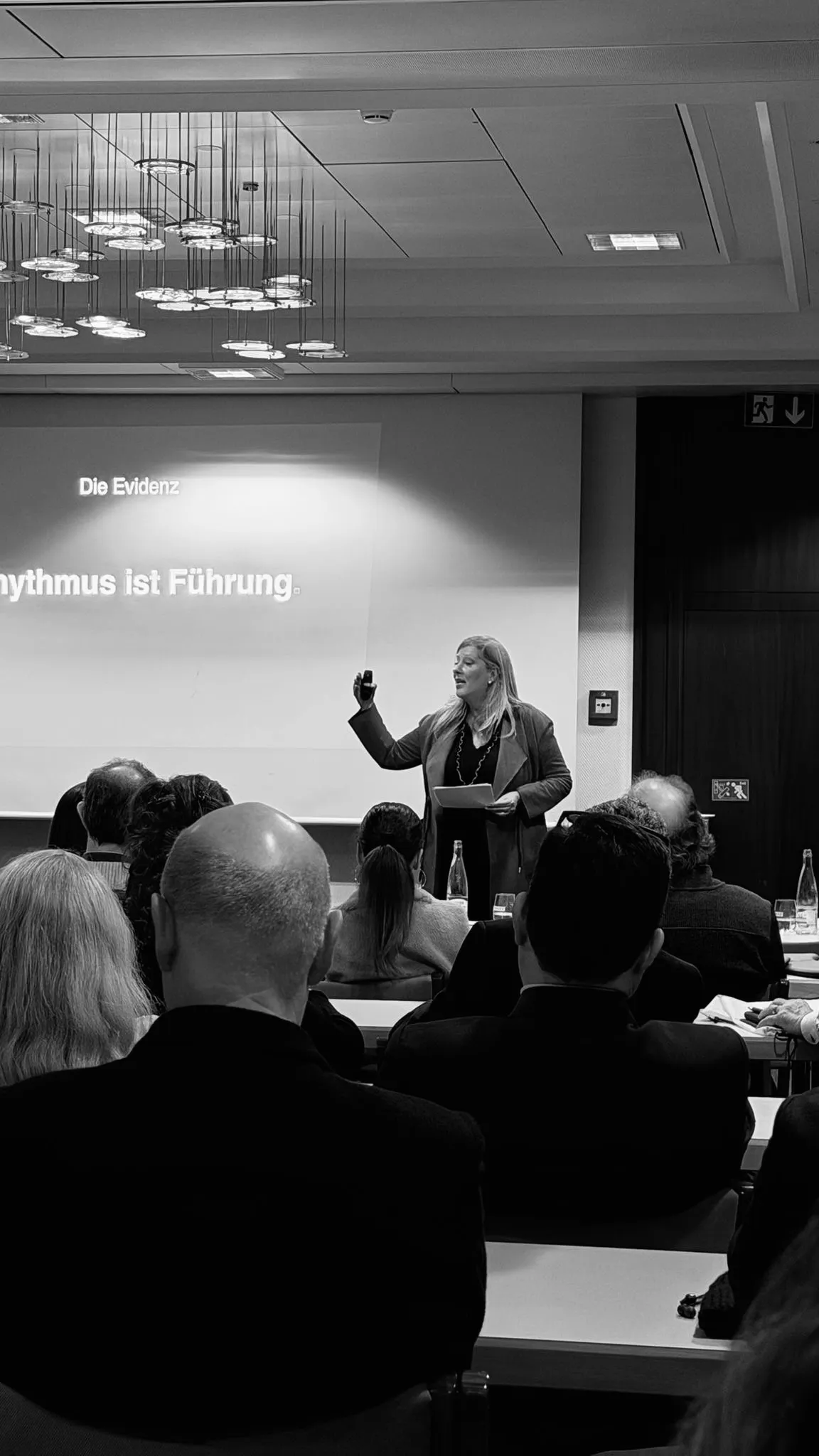Manuela Broz spricht vor Publikum, auf der Leinwand der Satz Rhythmus ist Führung